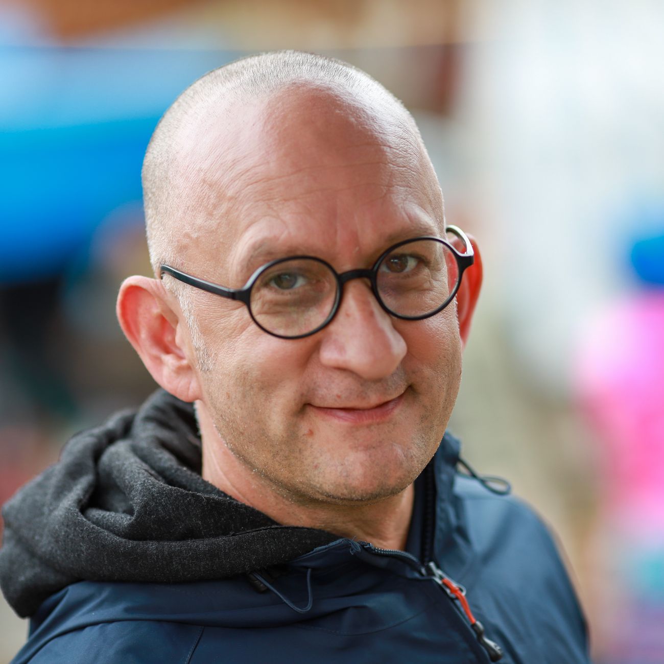 Man with glasses smiling outdoors